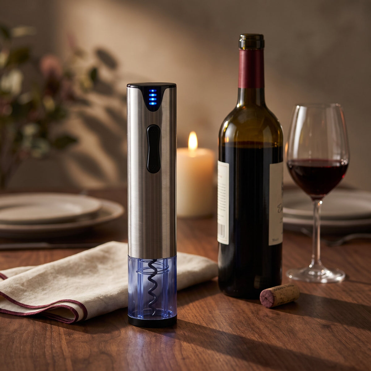 Tire-bouchon électrique usb posé sur une table en noyer à côté d'une bouteille de vin rouge et d'un verre