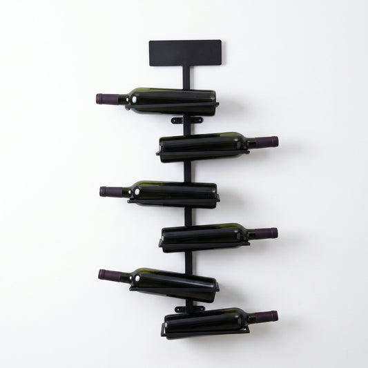 Porte-bouteille mural en fer noir avec quatre bouteilles sur fond blanc
