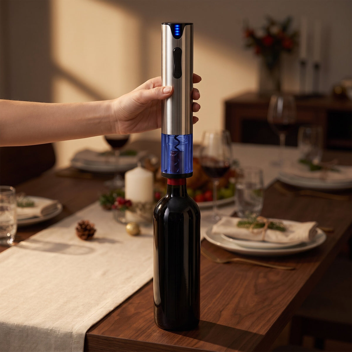 Main posant le tire-bouchon électrique usb sur le goulot d'une bouteille de vin