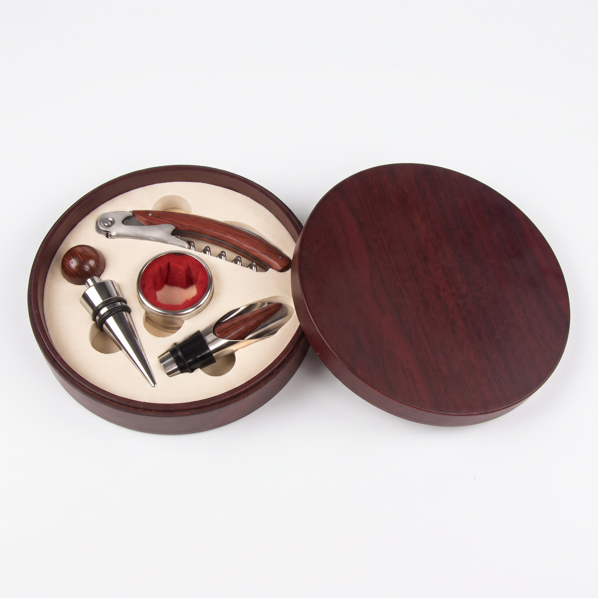 Coffret rond en bois avec tire-bouchon sommelier rouge, bouchon, collier et verseur sur fond blanc
