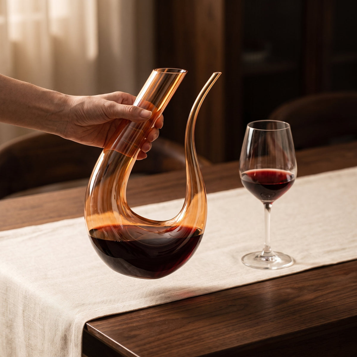 Carafe Cisne Gold tenue en main, verre ambré doré