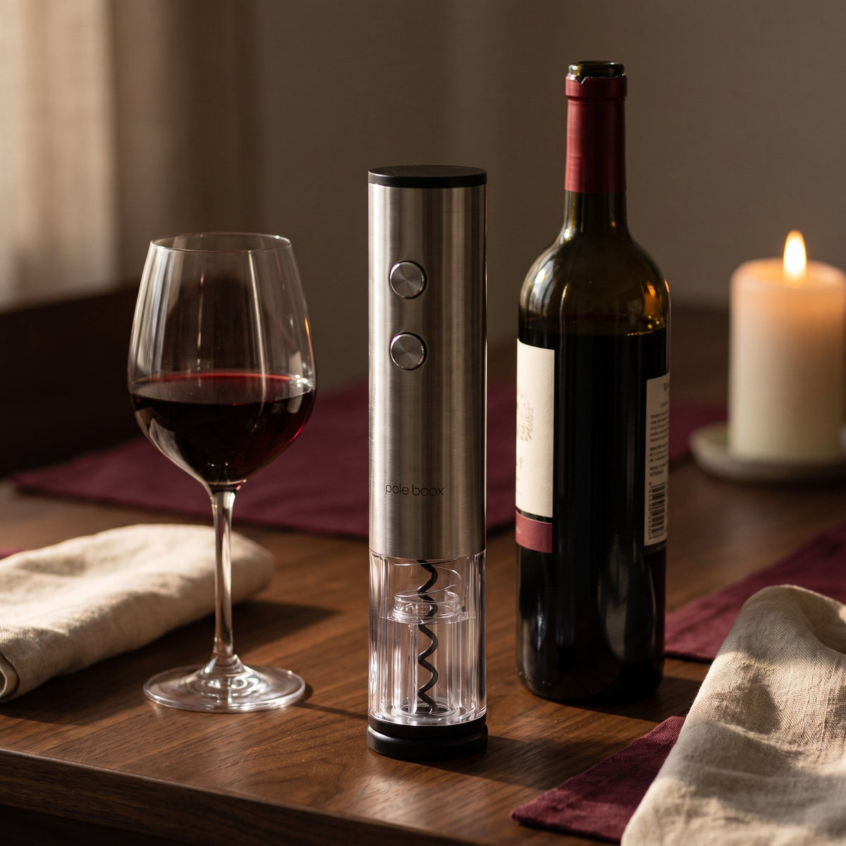 Tire-bouchon électrique acier brossé sur une table en noyer avec bouteille de vin rouge et verre
