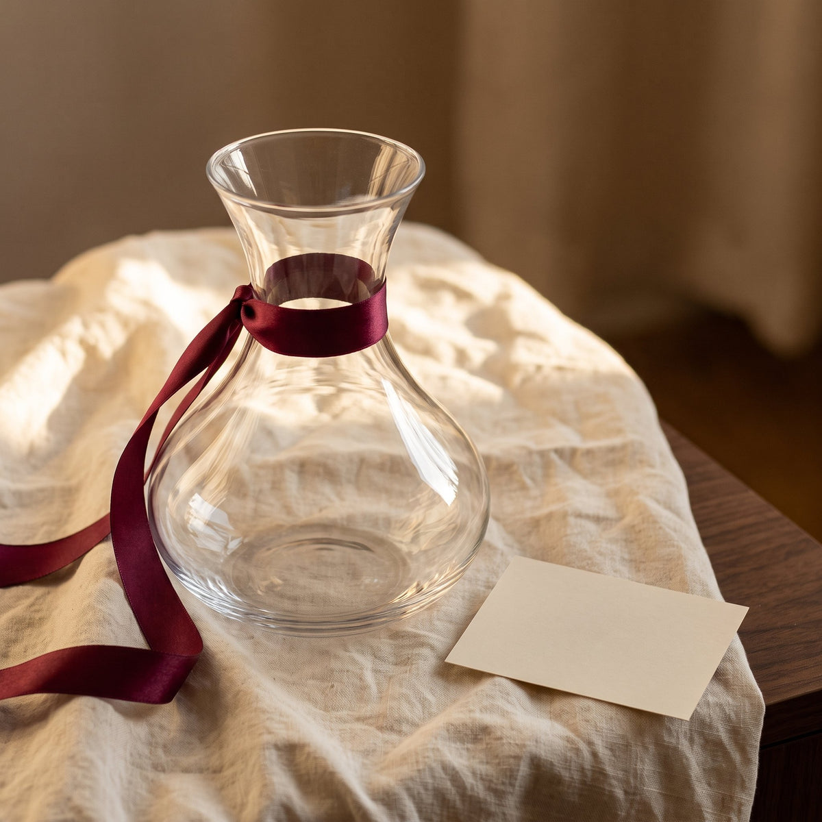 Carafe Bowl avec ruban cadeau bordeaux sur lin crème