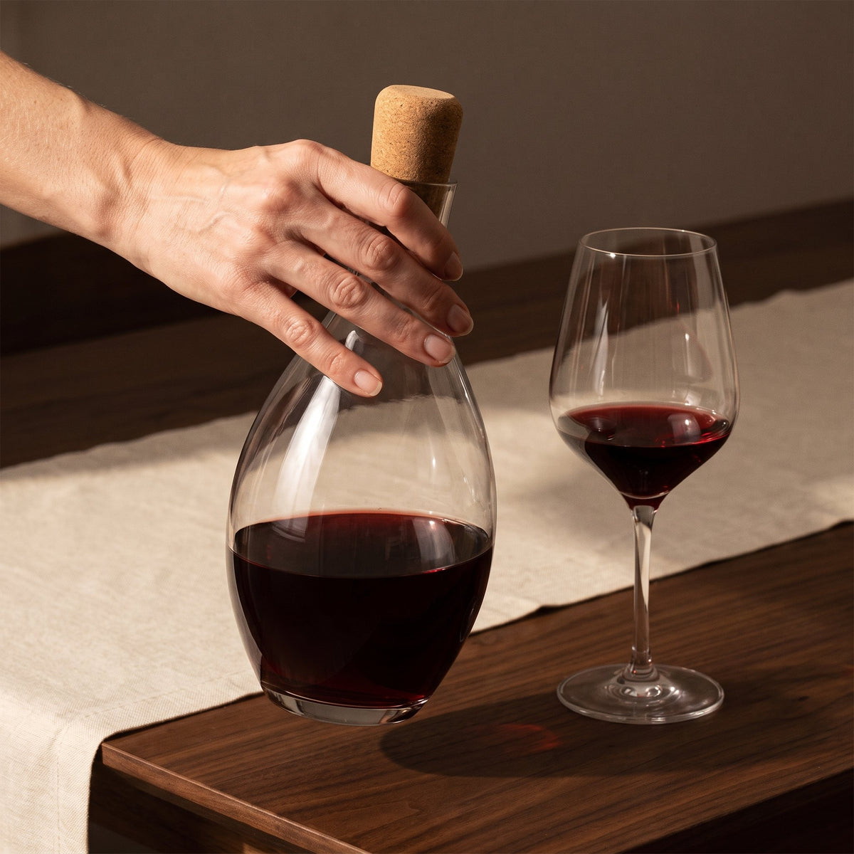 Carafe Olivy tenue en main, bouchon posé