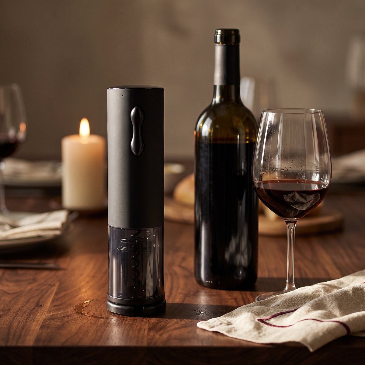 Tire-bouchon électrique Classe sur une table de dîner en noyer avec bouteille et verre de vin rouge