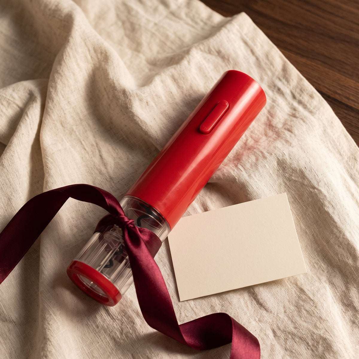 Tire-bouchon électrique Automatique Rouge présenté en cadeau sur lin crème avec ruban bordeaux