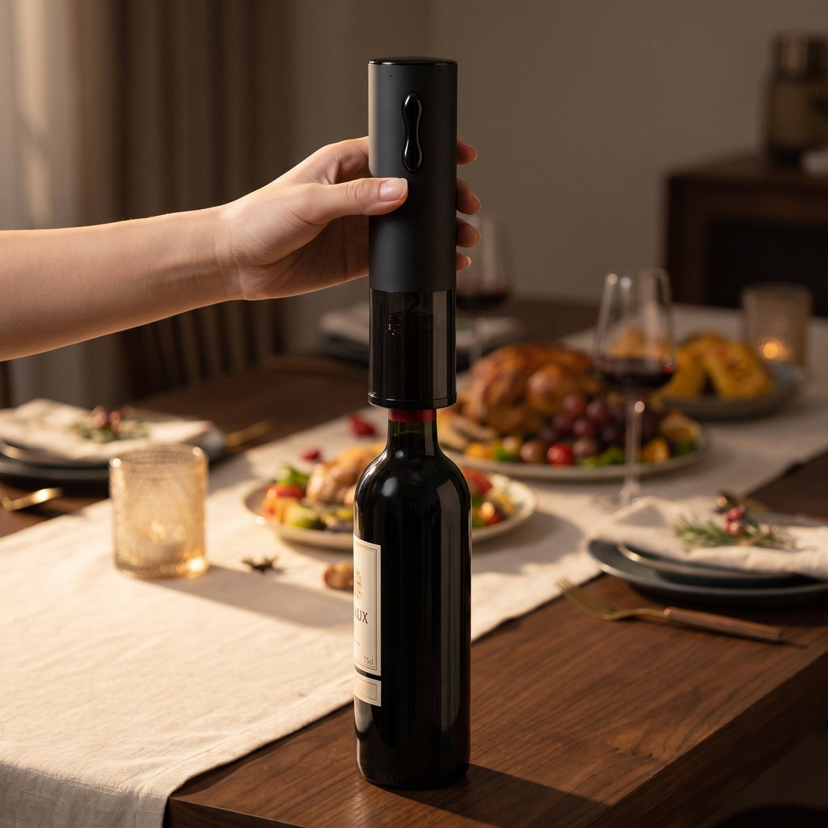 Main posant le tire-bouchon électrique noir sur le goulot d'une bouteille de vin