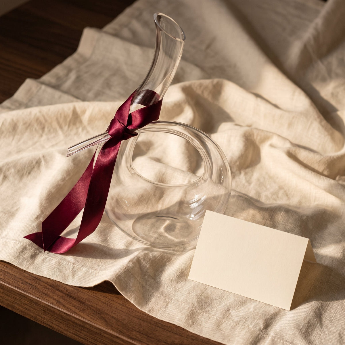 Carafe Lovelace avec ruban cadeau bordeaux sur lin crème