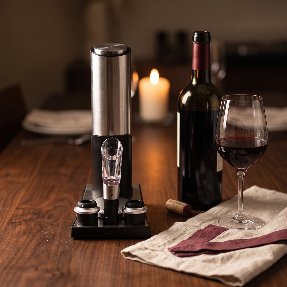 Tire-bouchon électrique Haute Gamme sur une table de dîner en noyer avec bouteille et verre de vin rouge