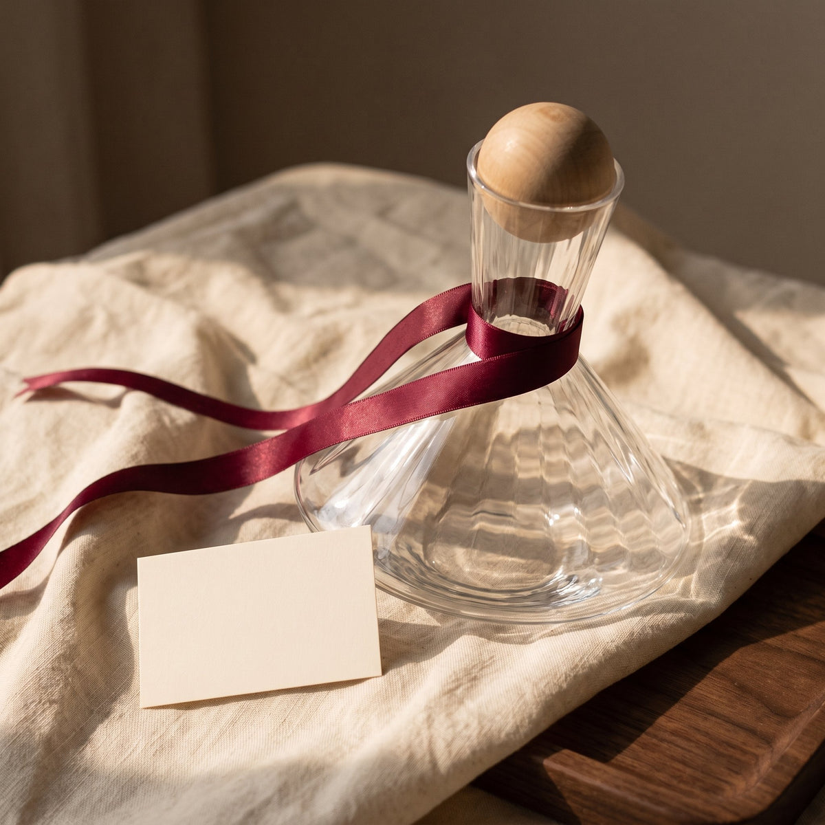 Carafe Spin Cork avec ruban cadeau bordeaux sur lin crème