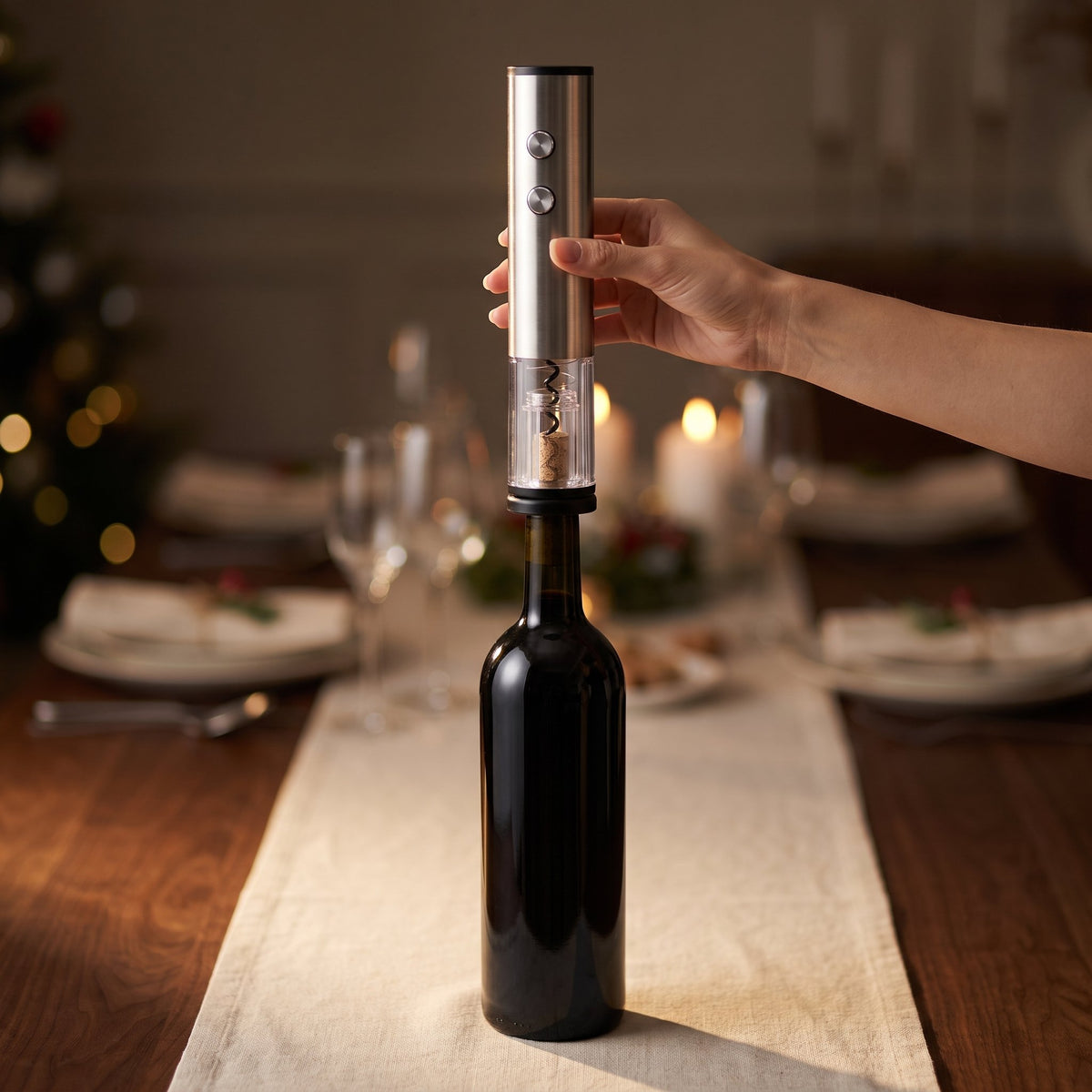 Main posant le tire-bouchon électrique sur le goulot d'une bouteille de vin