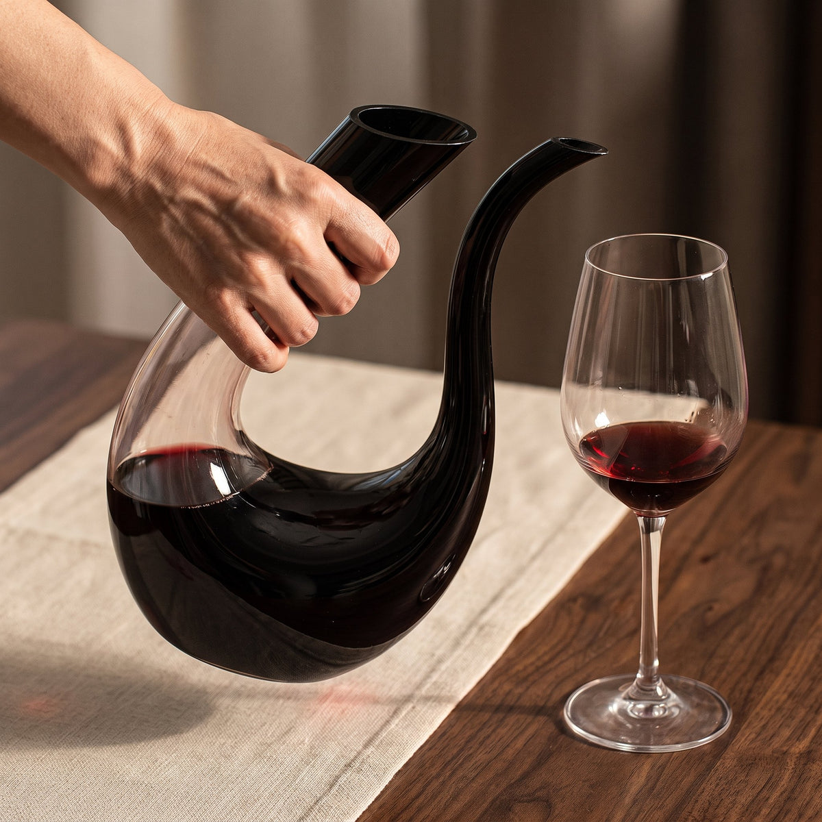 Carafe Black Swan tenue en main, silhouette de cygne noir