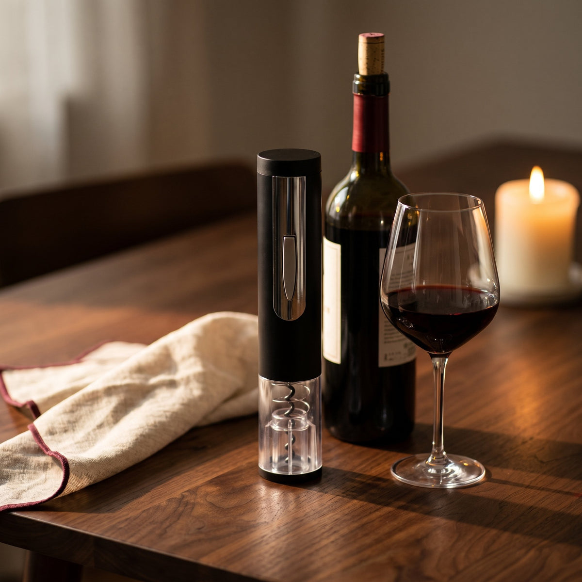Tire-bouchon électrique Vinomax sur une table en noyer avec bouteille de vin rouge et verre