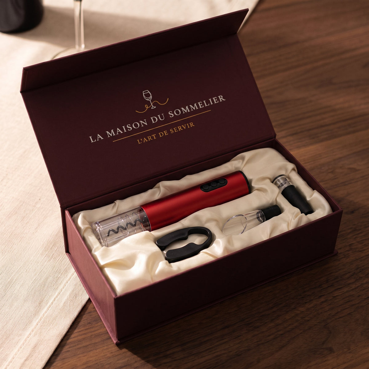 Coffret tire-bouchon électrique rouge ouvert : écrin bordeaux avec insert crème et accessoires