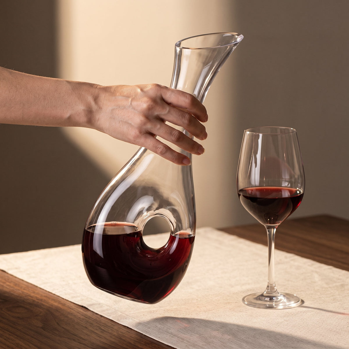 Carafe Purdey tenue en main près d'un verre à pied
