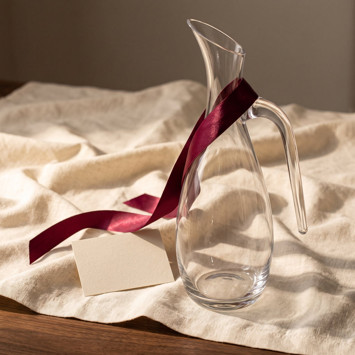 Carafe Évidence avec ruban cadeau bordeaux sur lin crème