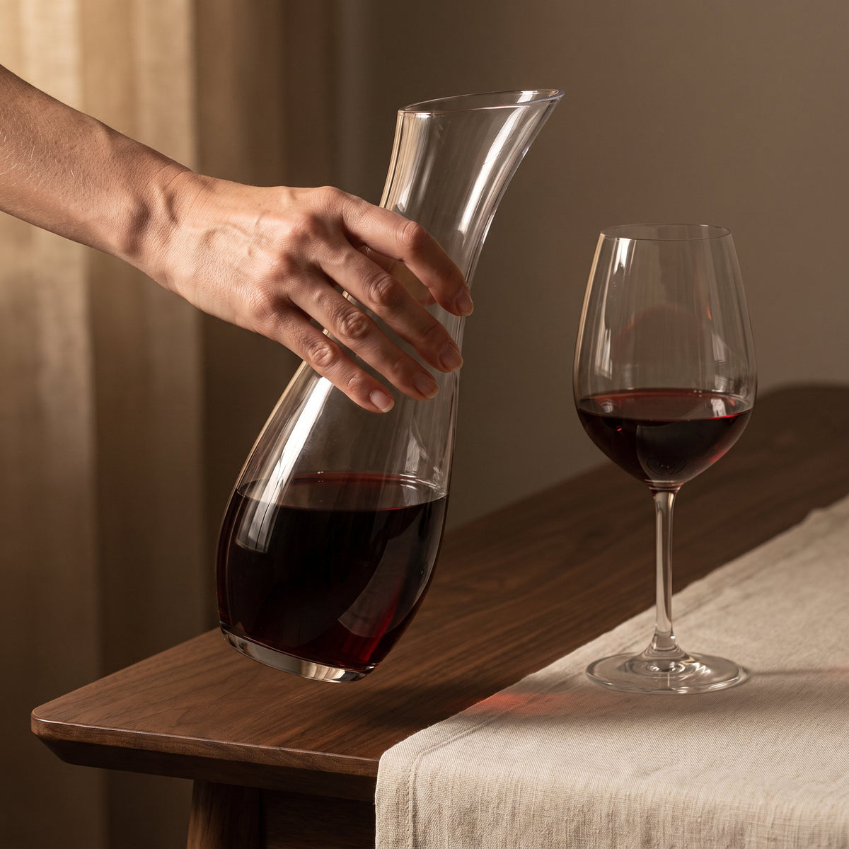Carafe Lonjeanne tenue en main au-dessus de la table