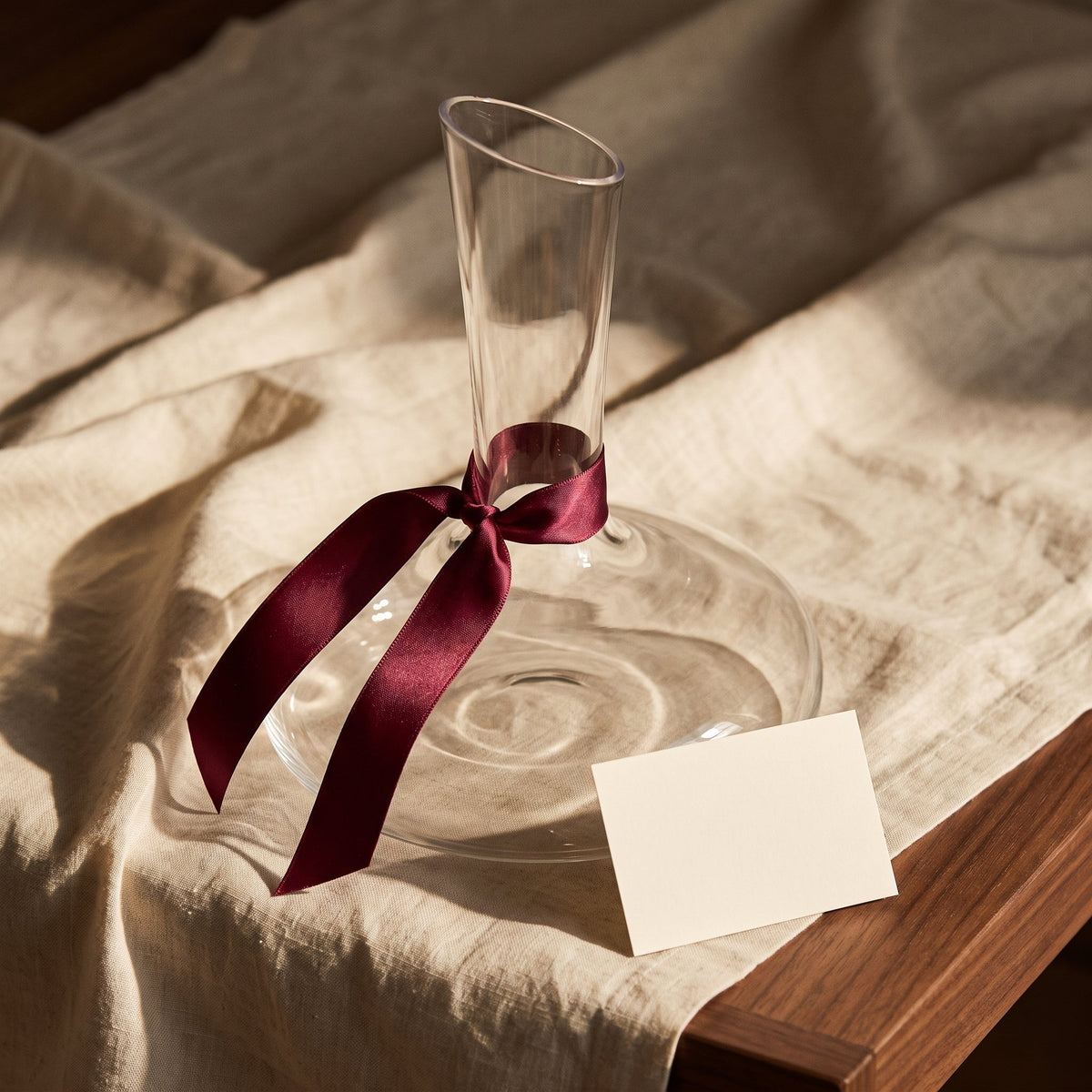 Carafe Demoiselle avec ruban cadeau bordeaux sur lin crème