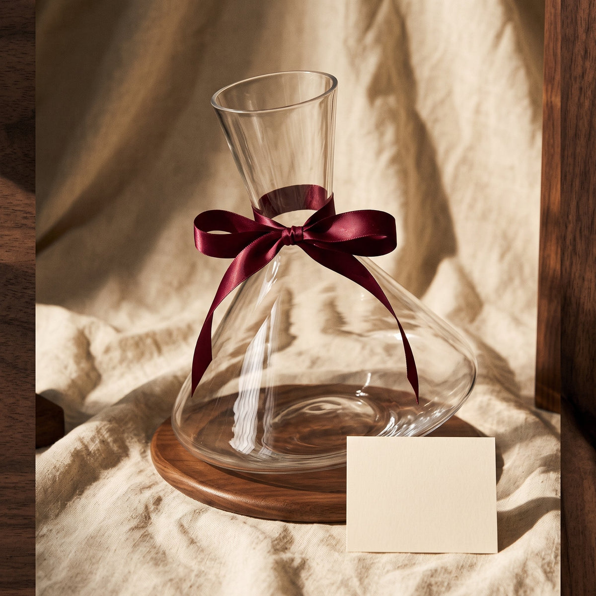 Carafe Culbuto Swing avec ruban cadeau bordeaux sur lin crème