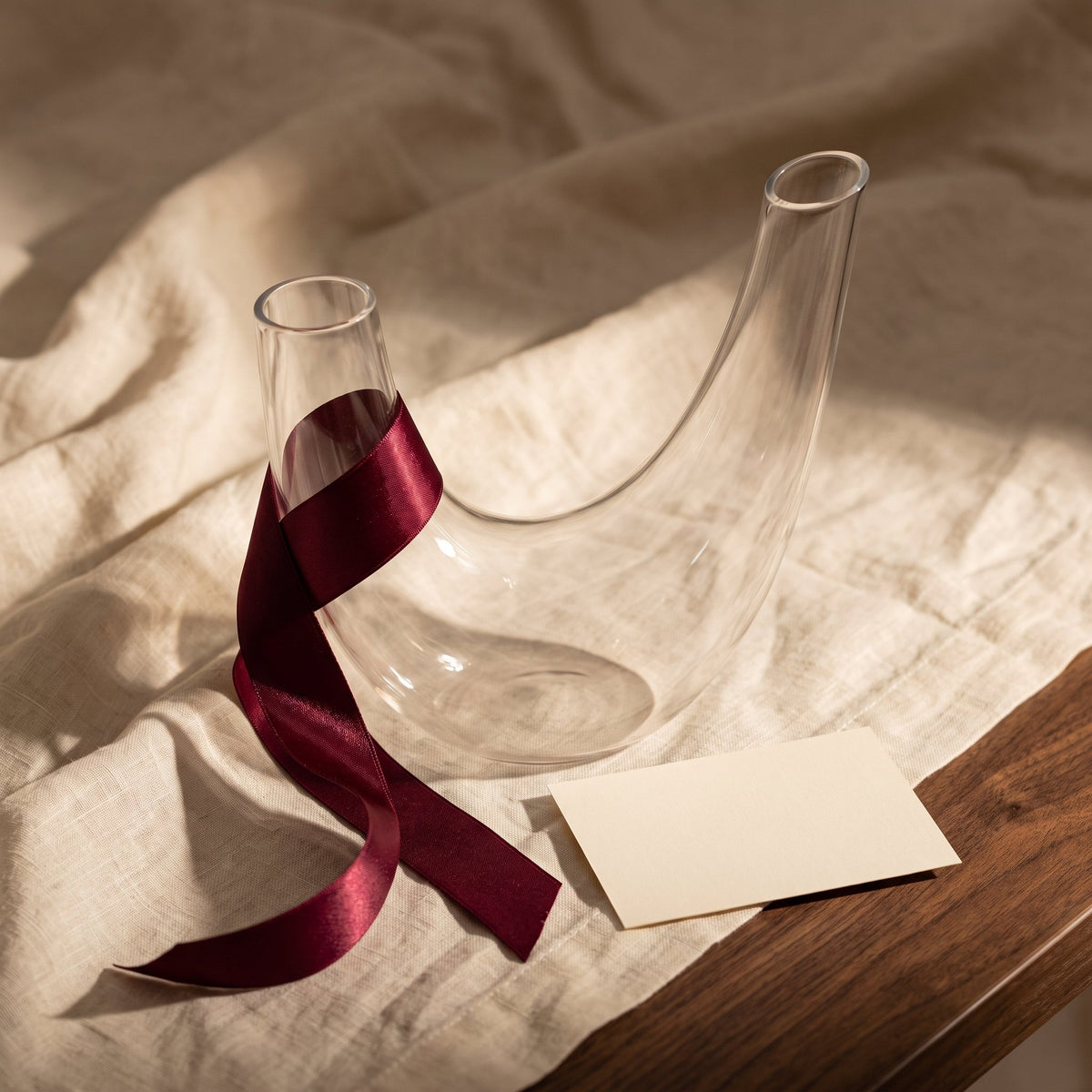 Carafe Horn avec ruban cadeau bordeaux sur lin crème