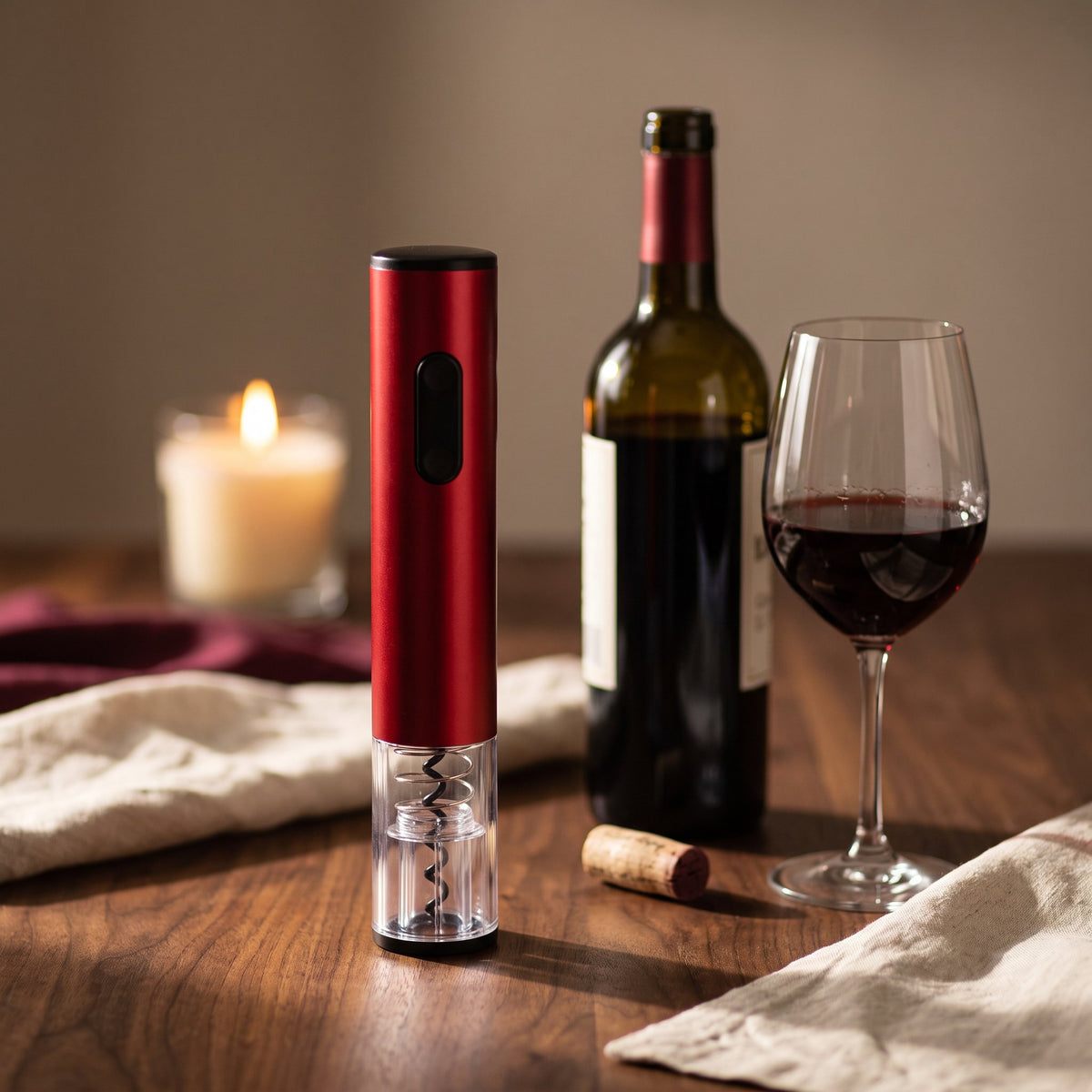 Tire-bouchon électrique rouge sur une table de dîner avec vin et bougie — La Maison du Sommelier