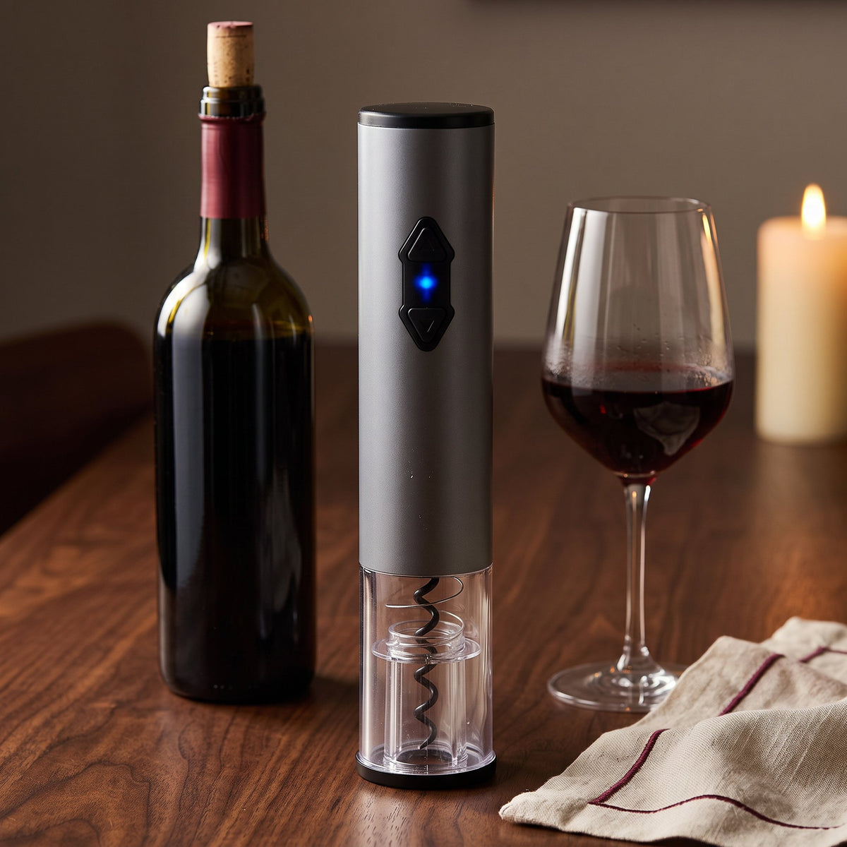 Tire-bouchon électrique Le Signature sur une table de dîner en noyer avec bouteille et verre de vin rouge
