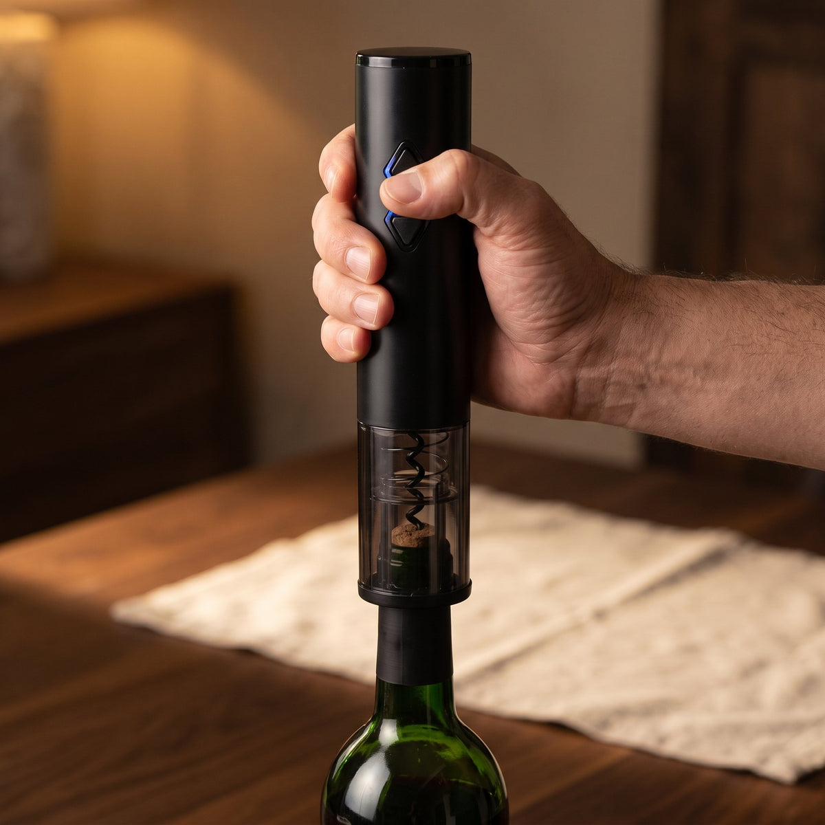 Main pressant le bouton lumineux du tire-bouchon électrique Rapide — La Maison du Sommelier