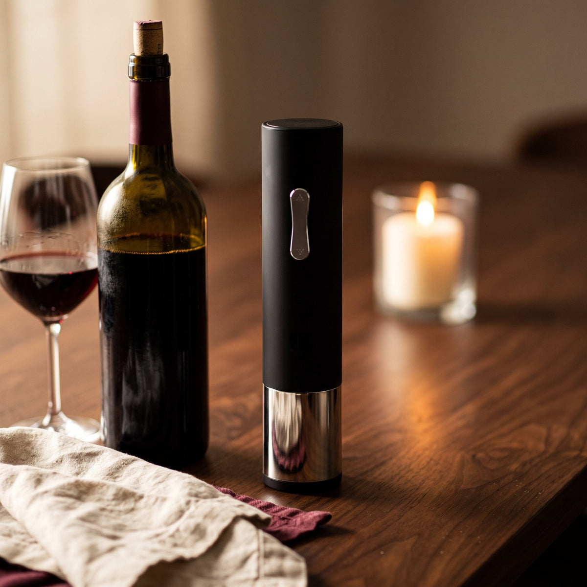 Tire-bouchon électrique Automatique sur une table de dîner en noyer avec bouteille et verre de vin rouge
