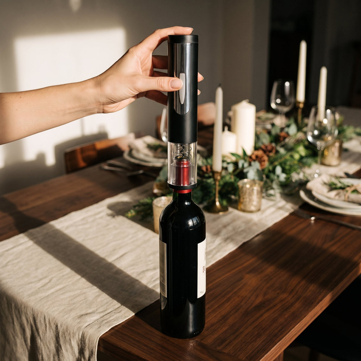 Main posant le tire-bouchon électrique Vinomax sur le goulot d'une bouteille